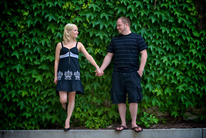 Engagement couple in front of ivy wall